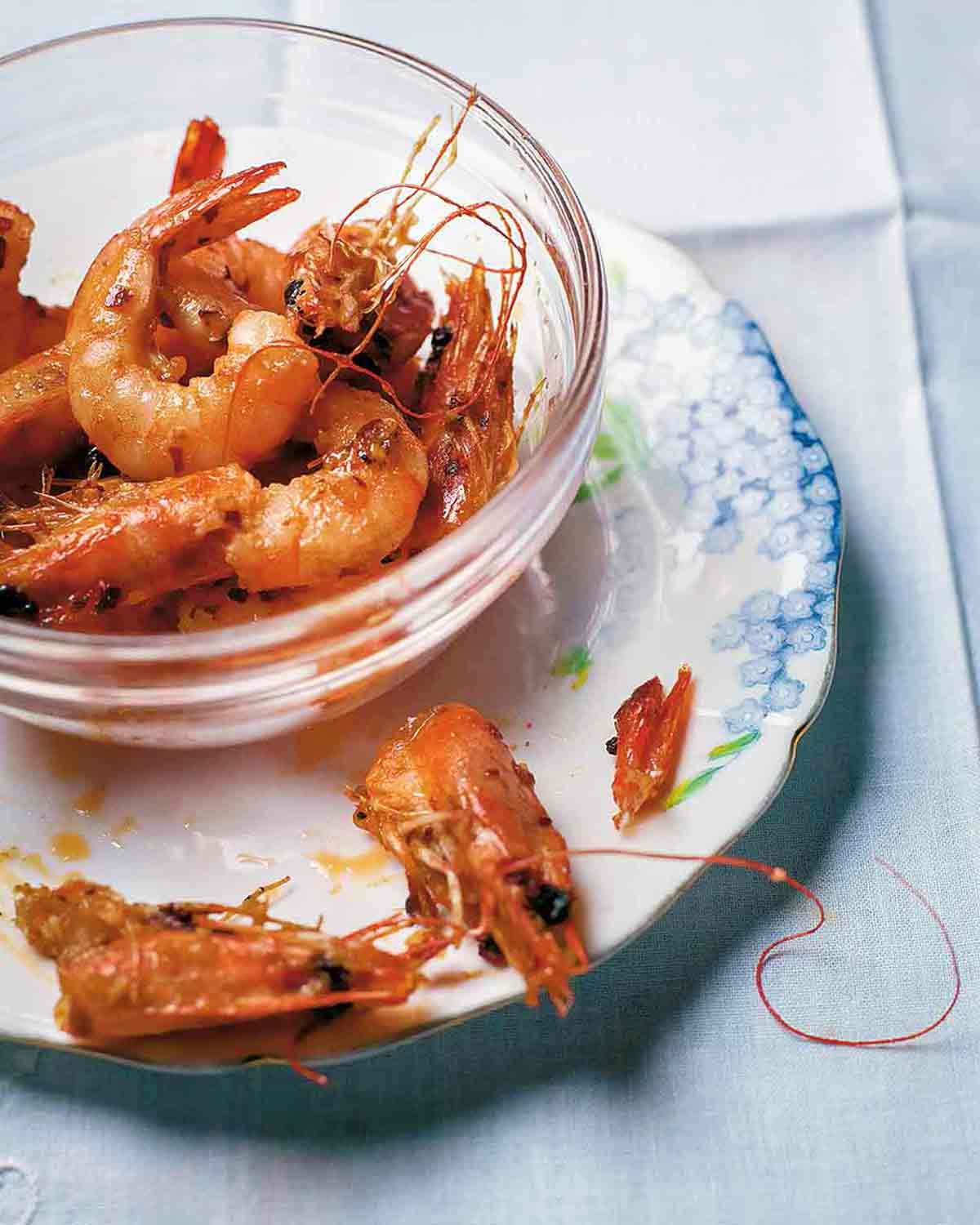 Glass bowl filled with garlic shrimp, sautéed with oil, butter, chiles pepper, and garlic