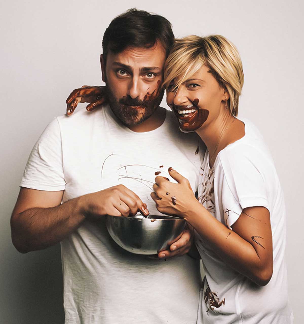 Cenk and a woman with their faces covered in chocolate.
