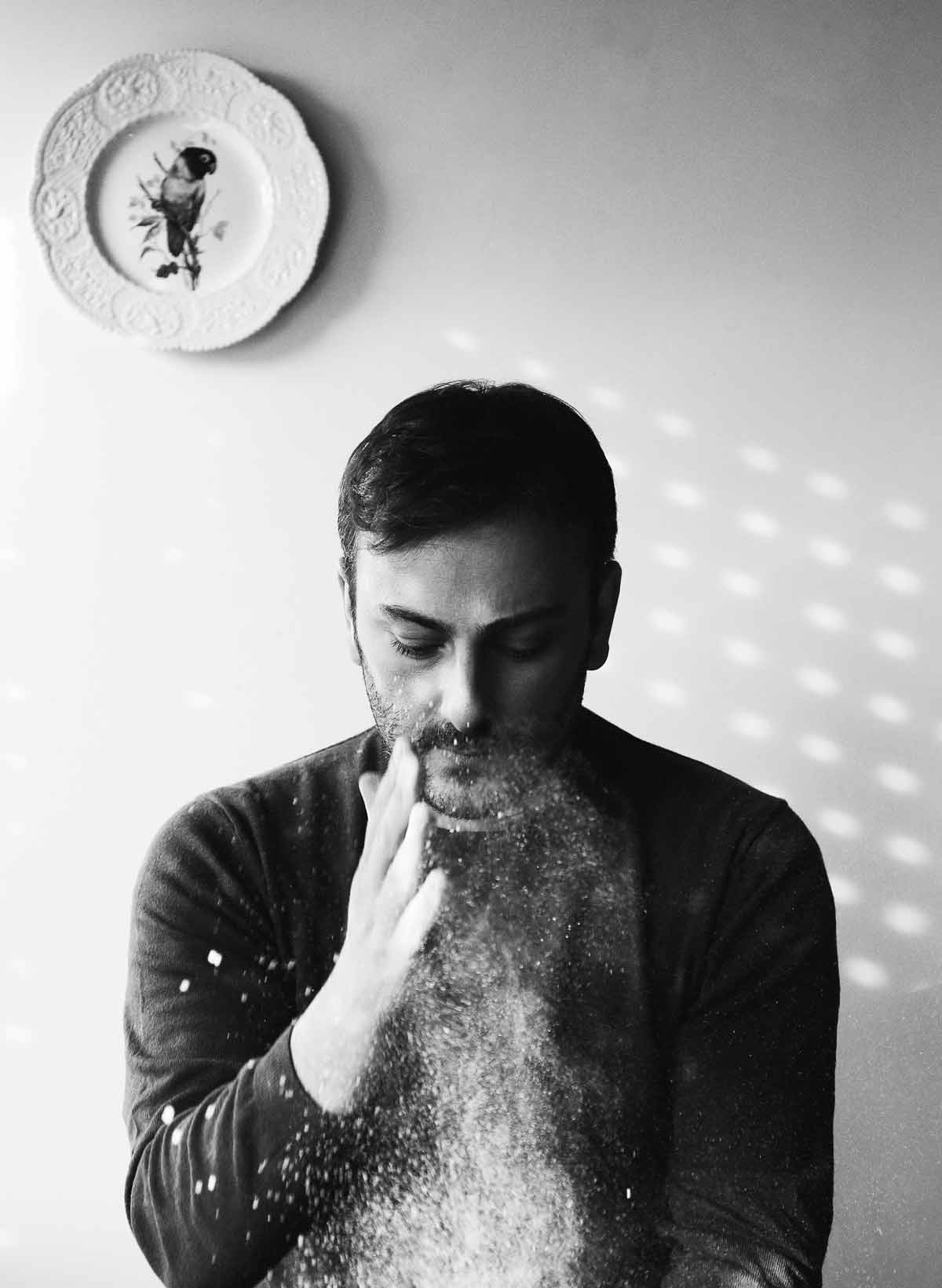 An image of Cenk Sönmezsoy dusting flour onto something.