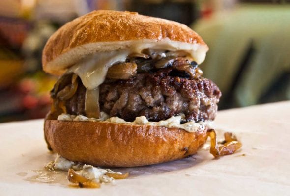 Big fat juicy burger with caramelized onions, melted cheese, and a toasted hard roll