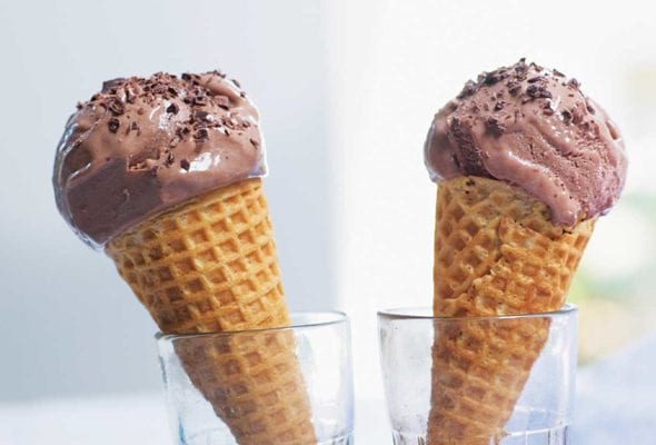 Two bitter chocolate and buttermilk ice cream cones in glasses.