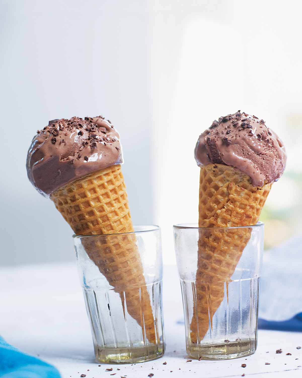 Two bitter chocolate and buttermilk ice cream cones in glasses.
