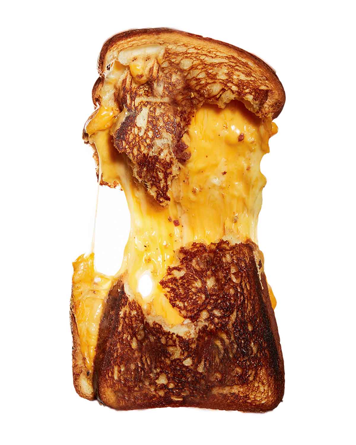 A challah grilled cheese sandwich torn in half, still connected by melted cheese.