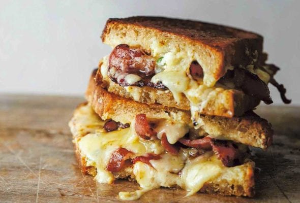 Two halves of grilled cheddar jalapeno popper sandwich stacked on top of each other