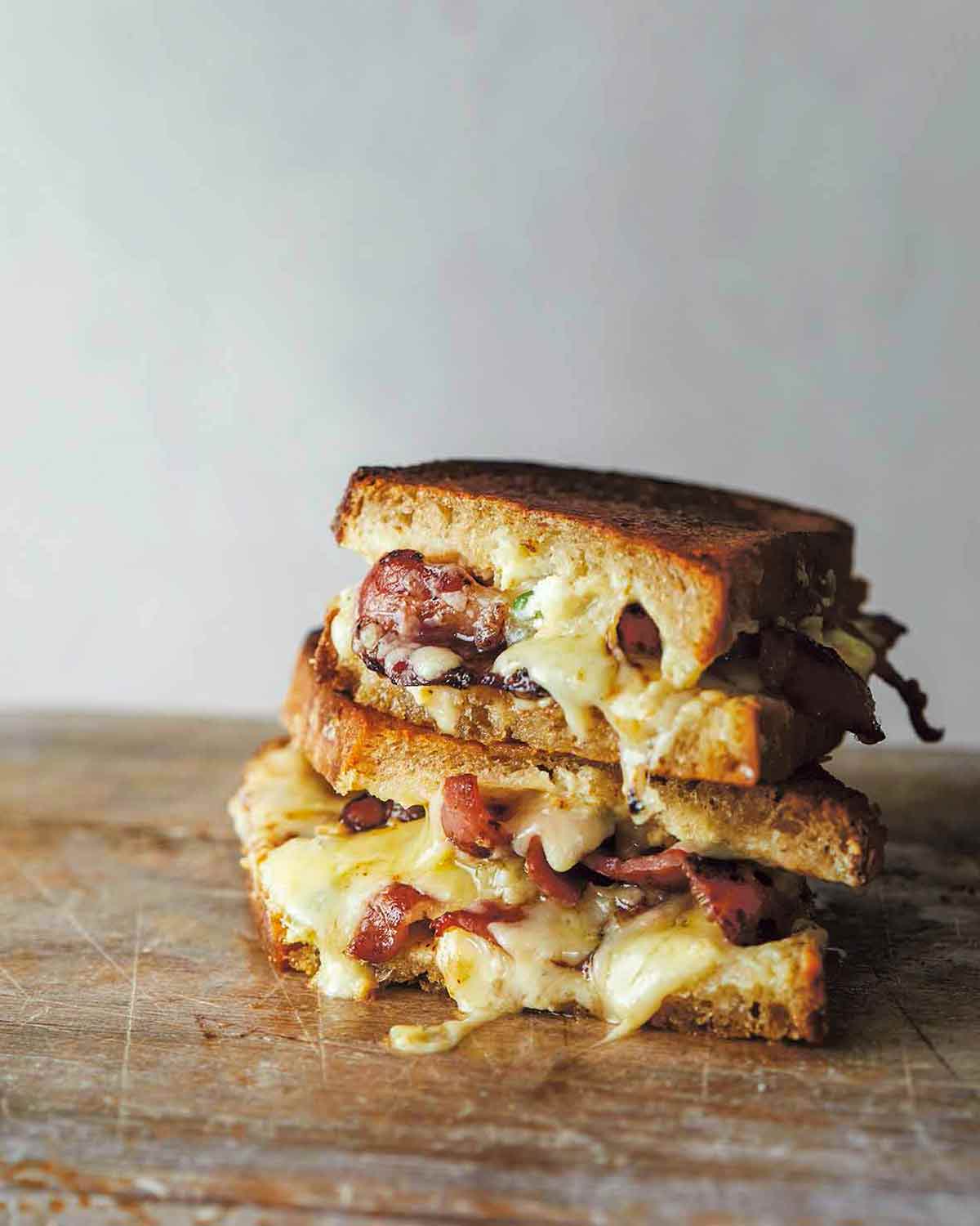 Two halves of grilled cheddar jalapeno popper sandwich stacked on top of each other