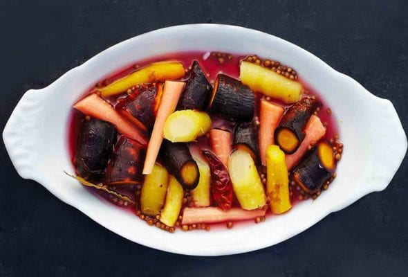 A white oval serving dish filled with pickled carrots.