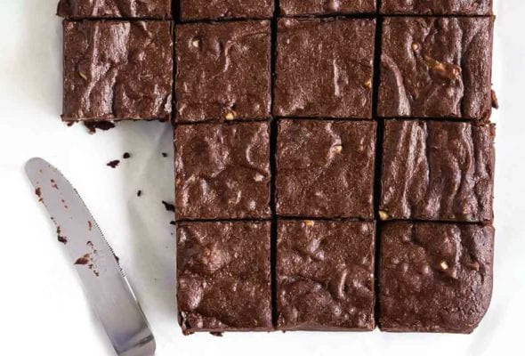 A batch of Rose Levy Beranbaum's fudge brownies cut into 16 squares, with two missing and a knife resting beside.