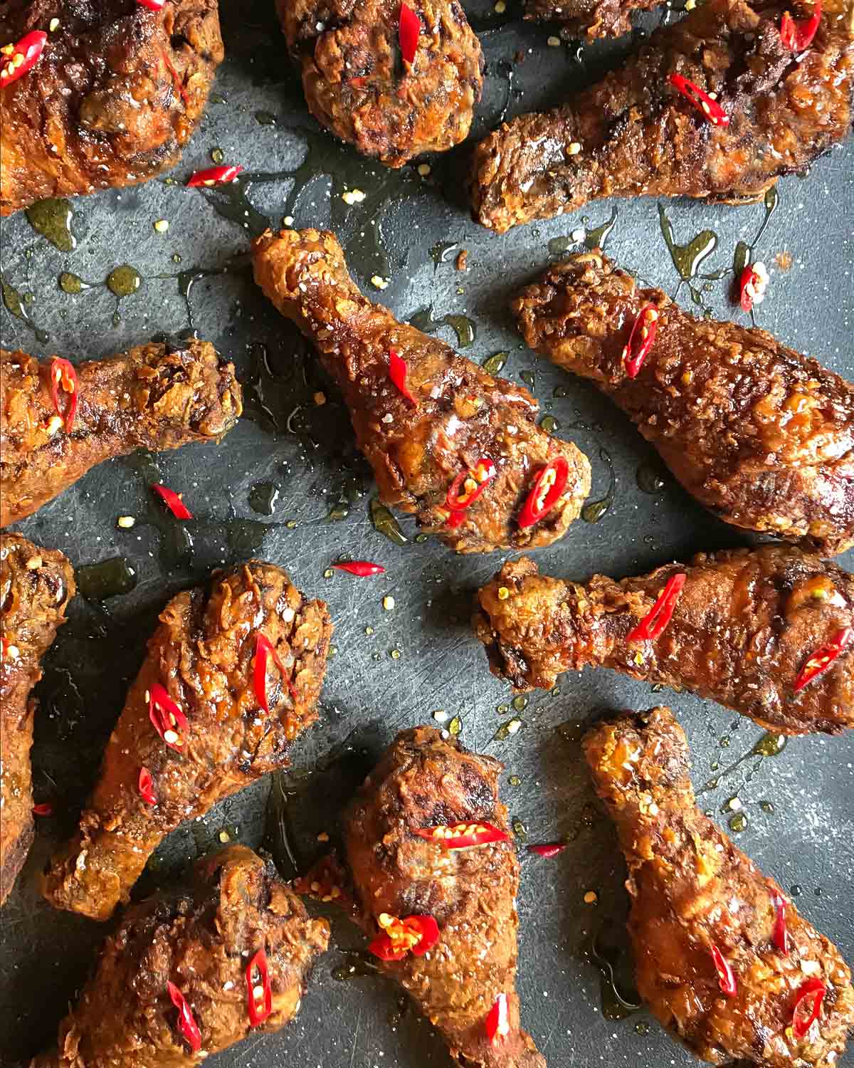 Pieces of bourbon buttermilk fried chicken on a metal background.