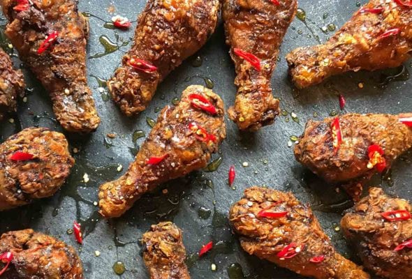 Pieces of bourbon buttermilk fried chicken on a metal background.