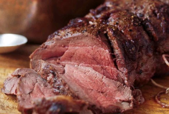A perfectly roasted beef tenderloin with Madeira sauce on the side ion a copper pot