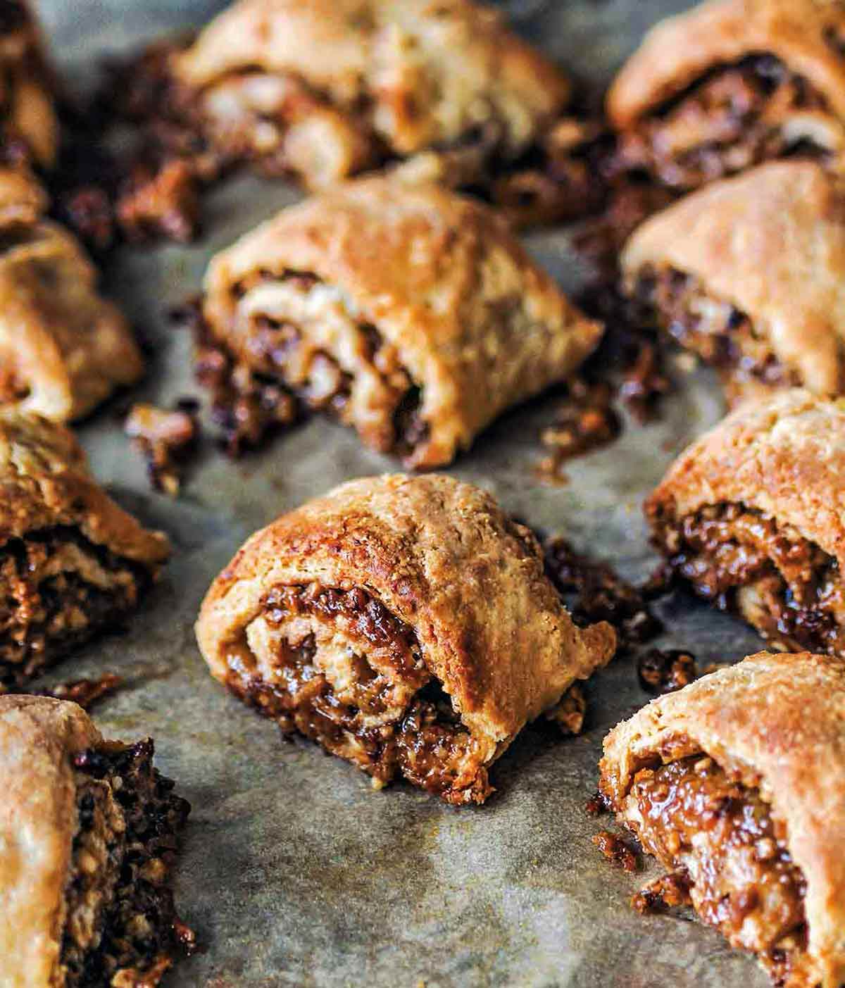 A dozen golden brown pecan pie rugelach with filling oozing out