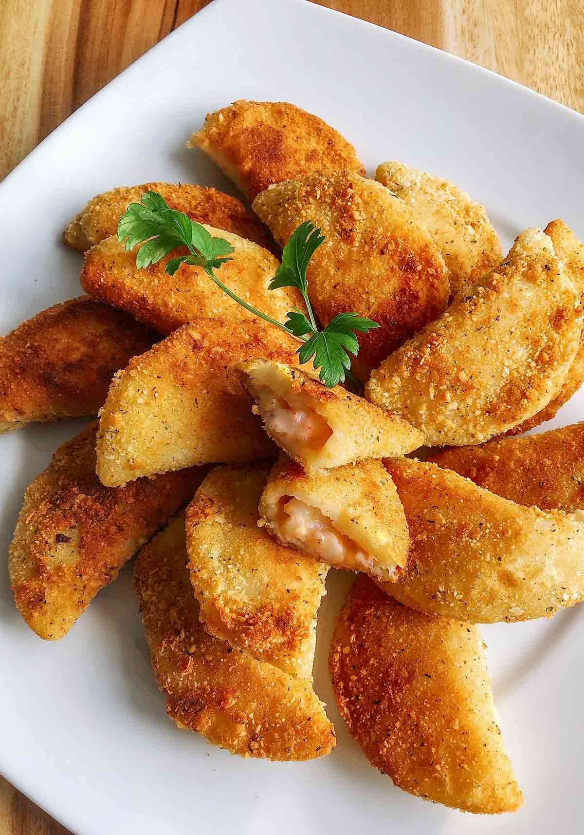 A platter of rissois de Camarao--or Portuguese shrimp turnovers--with one turnover cut open resting on top