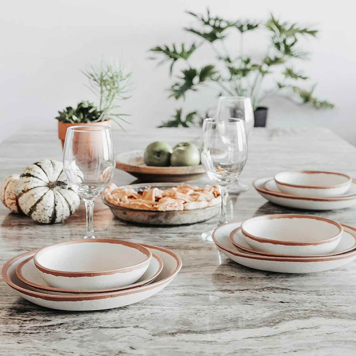 Q Squared Potter Collection Dinner Plate set on table with wine glasses and pie.
