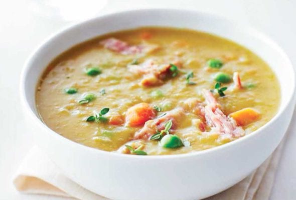 A white bowl filled with slow cooker split pea soup on a napkin.