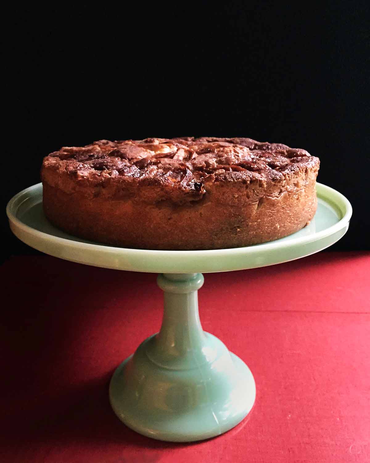 A super moist apple cake on a cake stand.