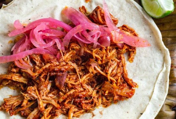 Pulled pork tacos with habanero salas and pickled onions on flour tortillas.
