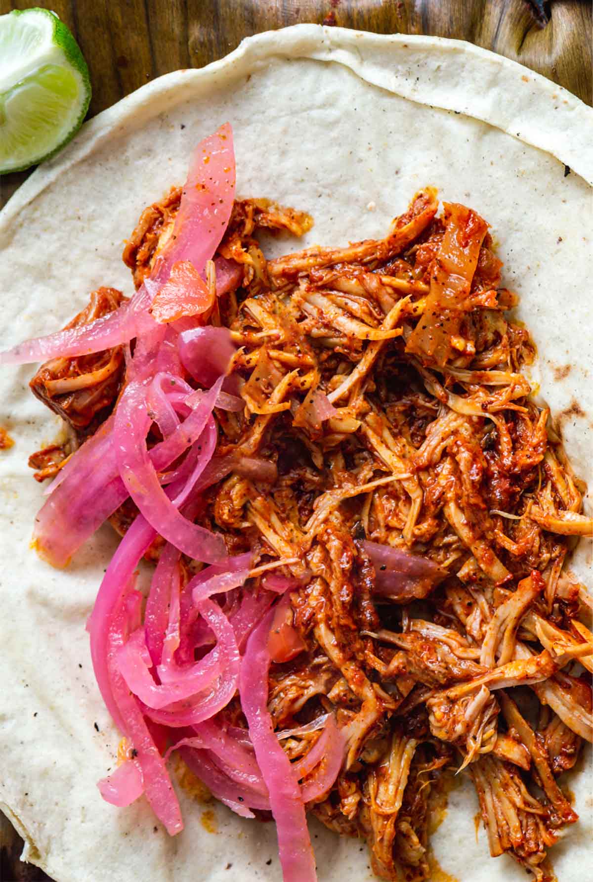 Pulled pork tacos with habanero salas and pickled onions on flour tortillas.