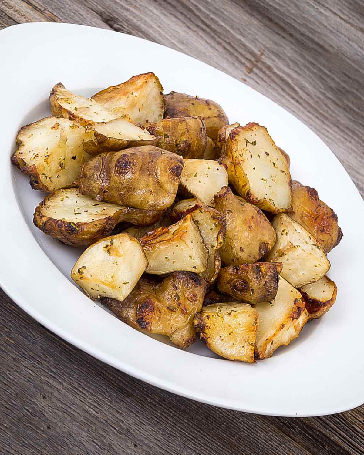 A white platted filled with roasted Jerusalem artichokes.
