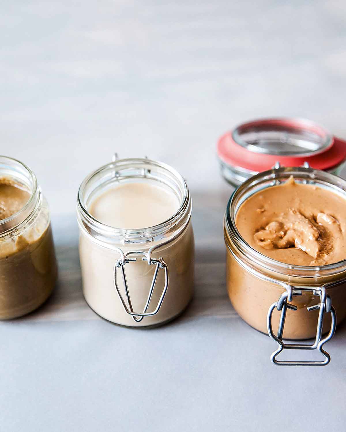 Three jars of homemade nut butter made with different nuts.