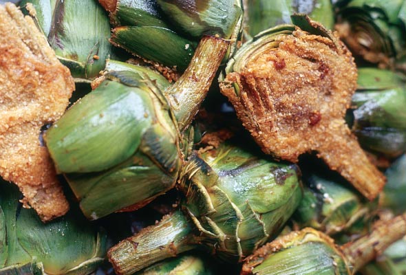 Several artichoke halves stuffed with beef and pan fried.